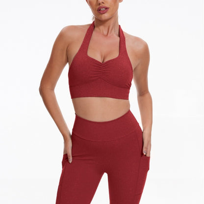 Woman wearing a red sports bra and leggings on a white background
